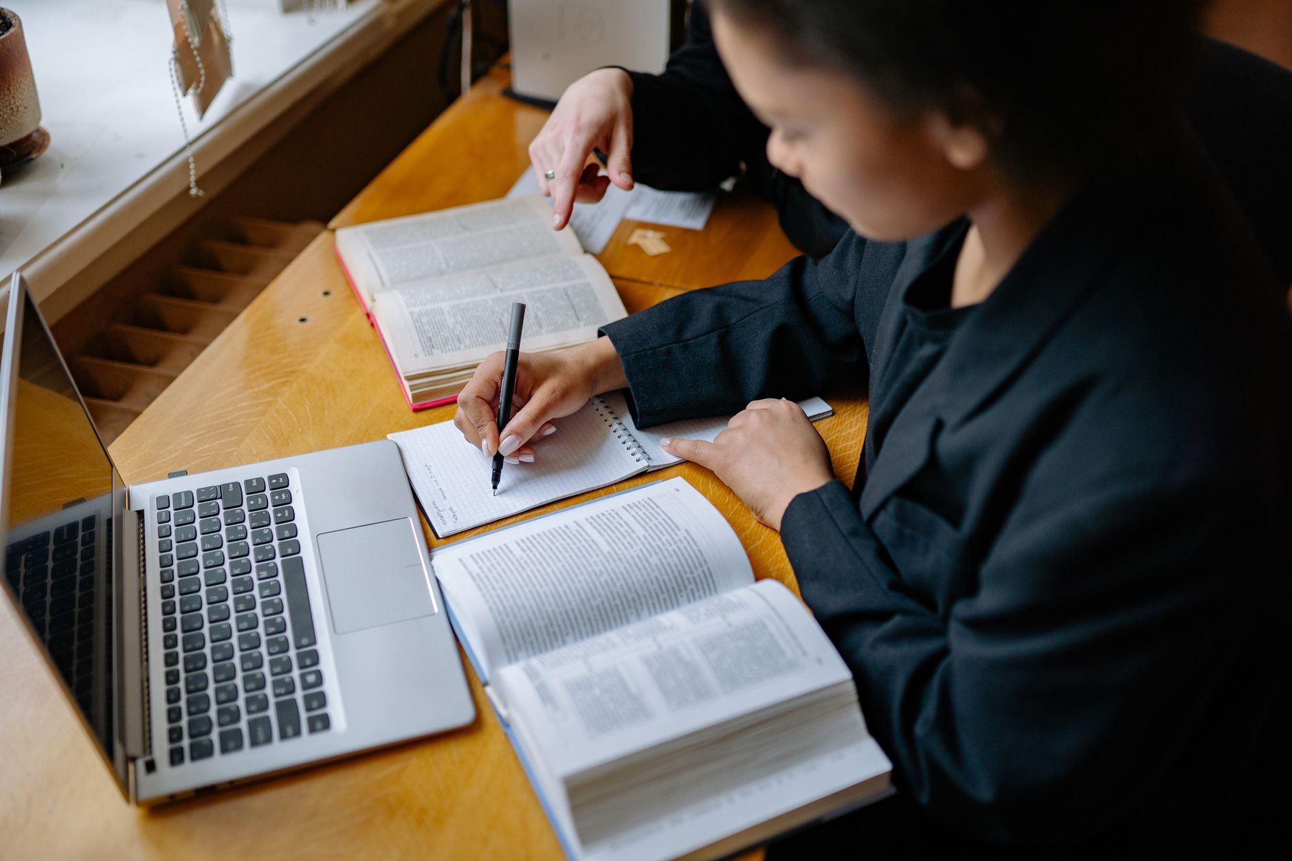 photographic | student taking notes next to a laptop displaying interactive chemistry graphs