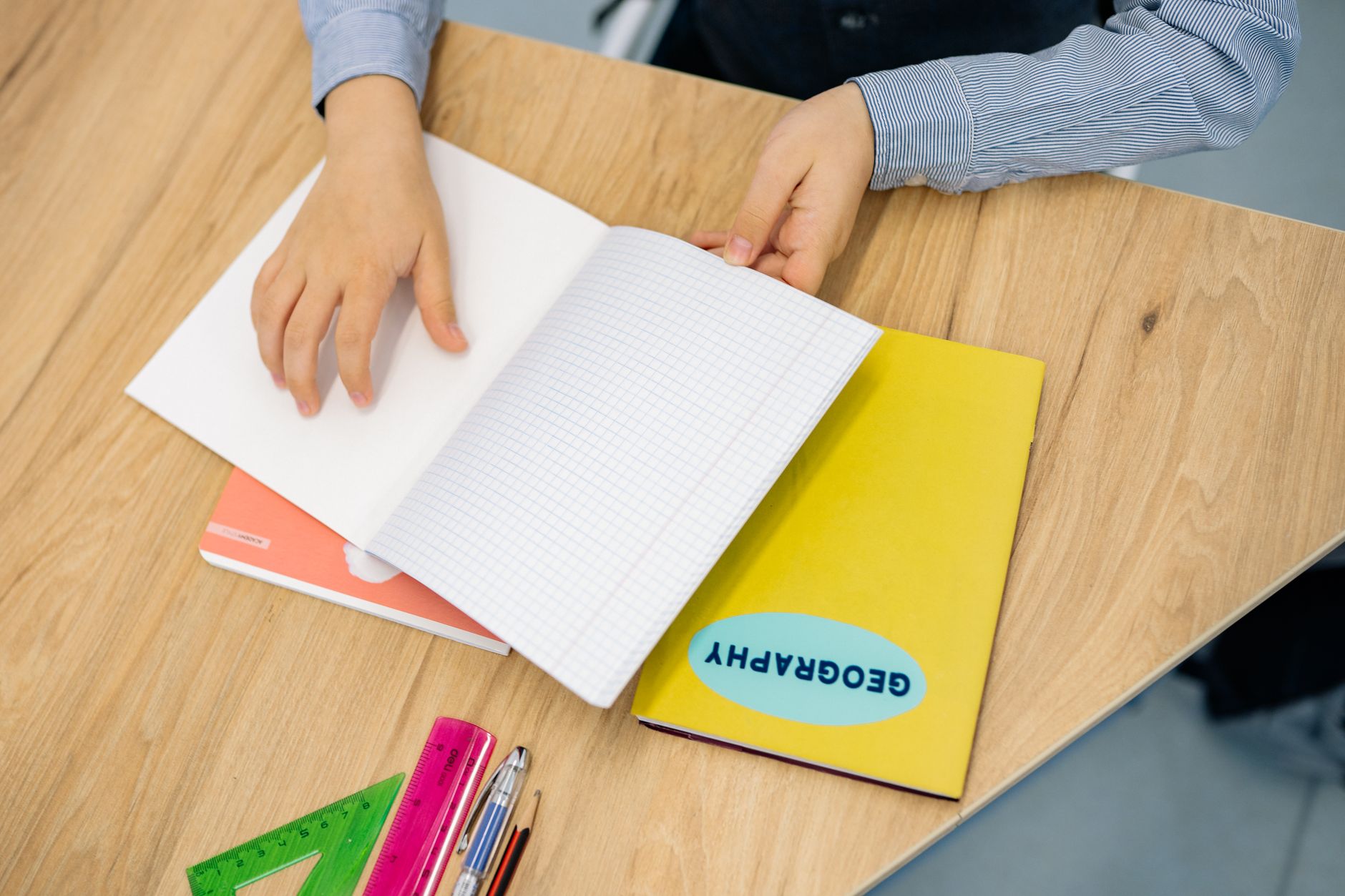photographic | student sitting at a clean wooden desk with open notebook and timer