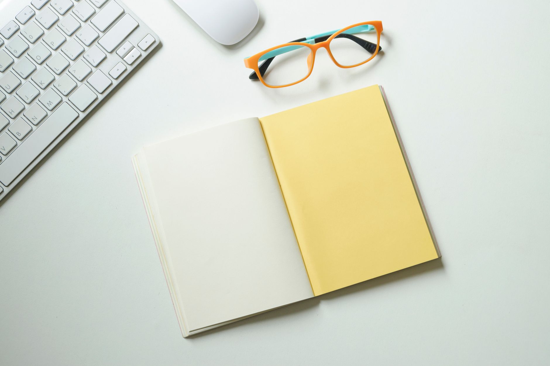 photographic | student sitting at a clean wooden desk with open journal and laptop writing focused notes